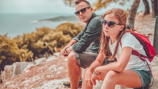 A teen girl being mean to her dad on a hiking trip