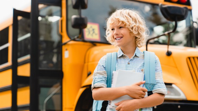 posing in front of the school bus is one of our favorite first day of school picture ideas