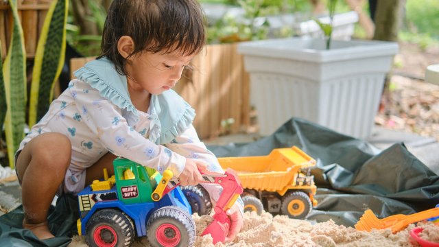 little girl playing with trucks