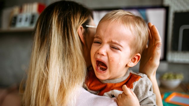 a mother holding a crying kid for a story on night terrors in toddlers