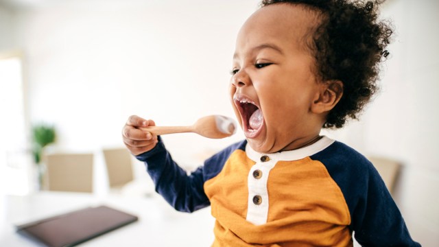 a toddler eating yogurt, one of the ways to get protein for kids