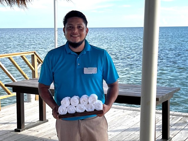 Employee at Margaritaville Beach Resort Ambergris Caye greeting guests with cold towels