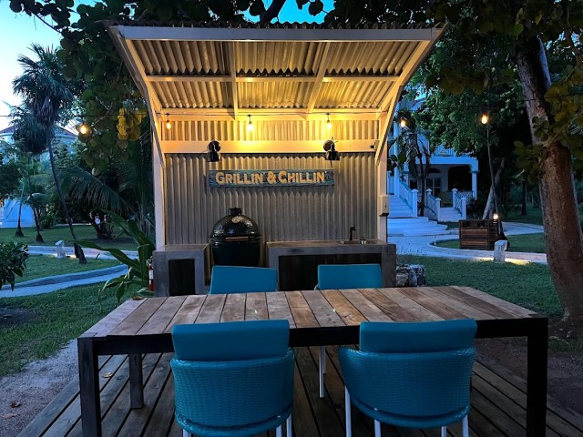 Grilling area with table, four chairs, sign that says Grillin' and Chillin' and Big Green Egg