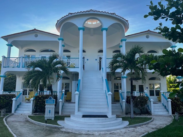 Two story white building with suites inside and stairs going up front. Sign on bottom left says Coconut Telegraph 8.