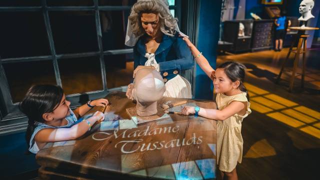 Two girls standing next to wax figure at Madame Tussauds in Orlando, Florida