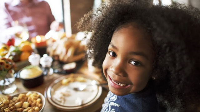 little girl smiling at Thanksgiving jokes