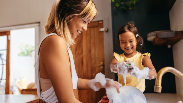 mom and toddler daughter doing dishes