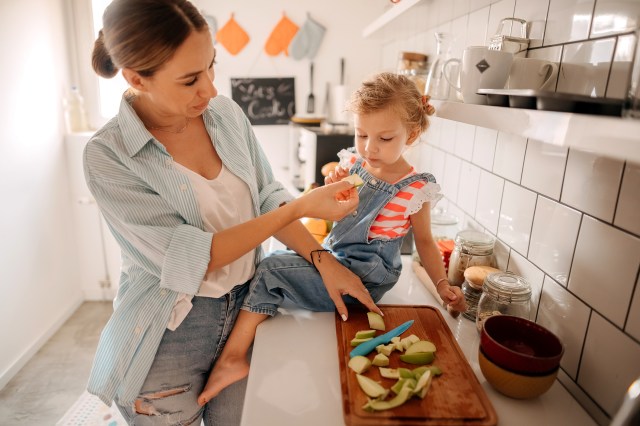 Mom feeding daughter apple as it offers constipation relief for kids