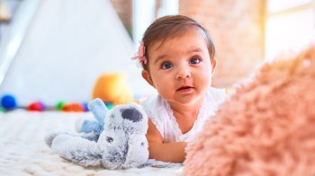A puppy lovey for baby lying on the floor looking adorable