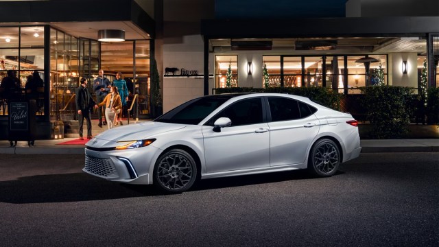 A white Toyota Camry parked outside a restaurant, one of the best family cars of 2025