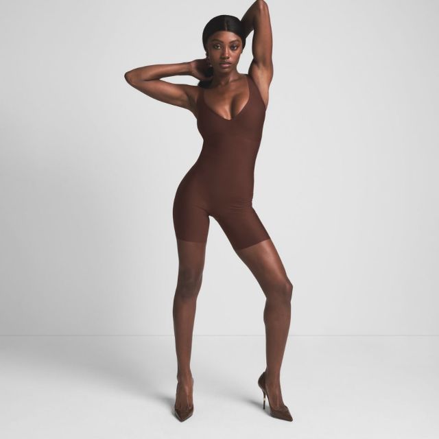 woman wearing dark brown shorts bodysuit shapewear