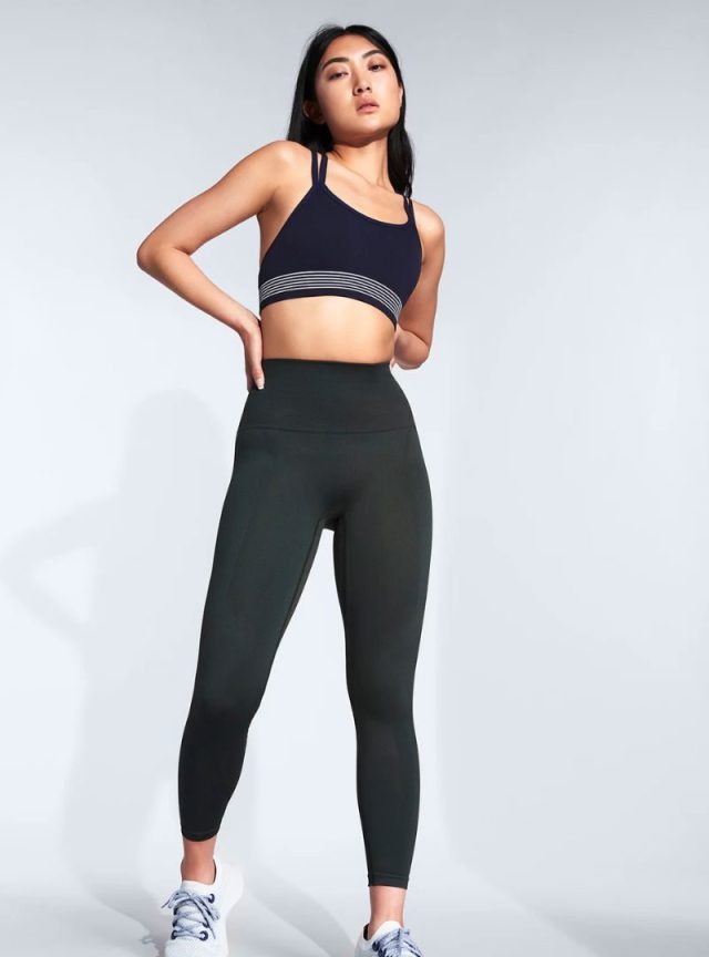 woman in sports bra, leggings, and sneakers