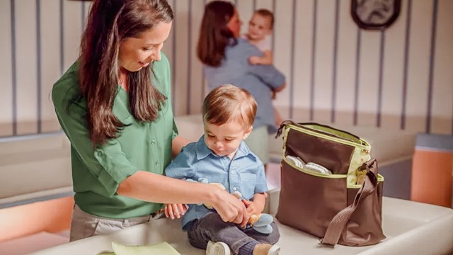 a mom changing her baby at a disney baby care center