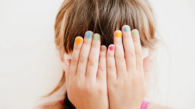 child hiding face with hands
