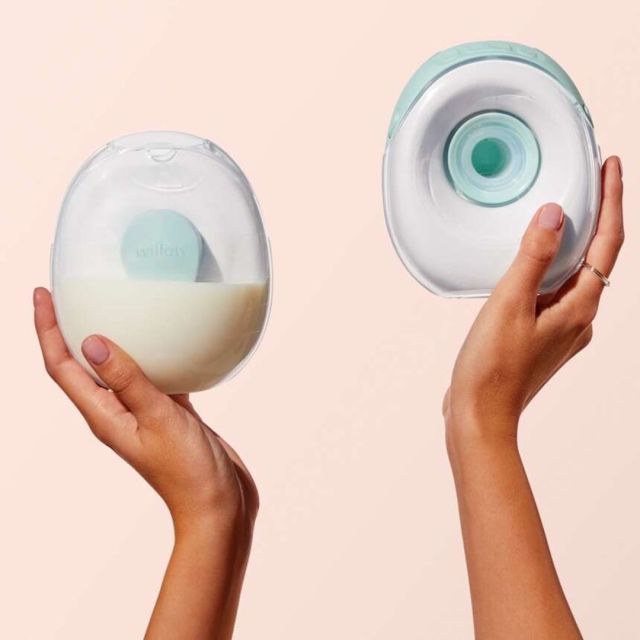 hands holding wearable breast pumps