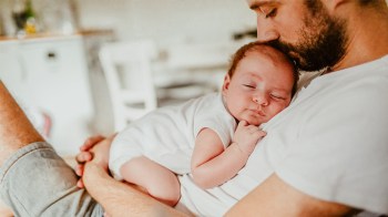 baby sleeping on dad who is wondering 'do babies dream'