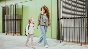 a mom in scrubs walking with her daughter for a story on advice for working moms