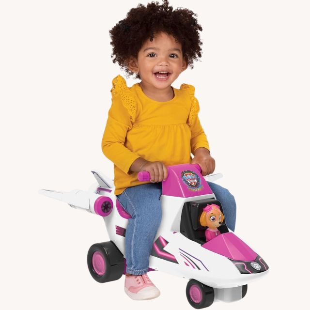 little girl riding a Paw Patrol themed toddler plane ride-on toy