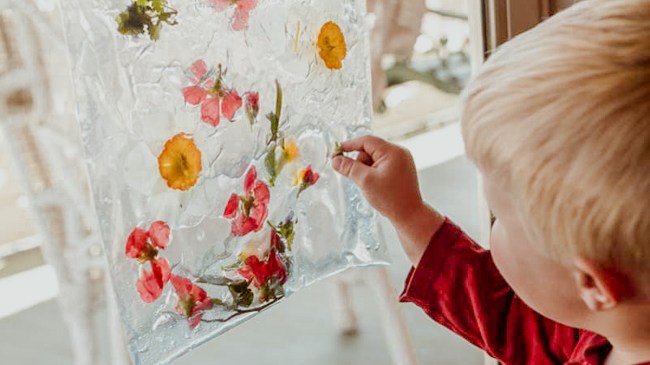 a little boy doing a spring sensory activity making a suncatcher