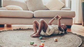 a tired toddler playing while her mom probably wonders when do toddlers drop naps