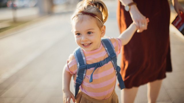 toddler girl about to run away from parent in a parking lot