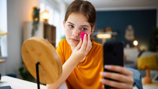 tween girl doing makeup and skincare regimen in her room