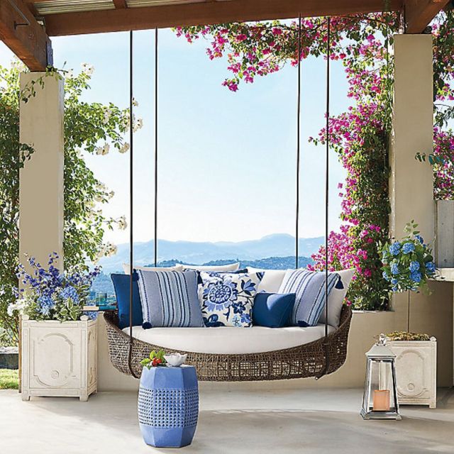 suspended outdoor daybed swing with cushions on coastal porch