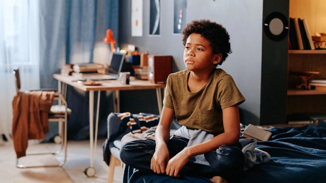 boy being defensive while sitting on bed