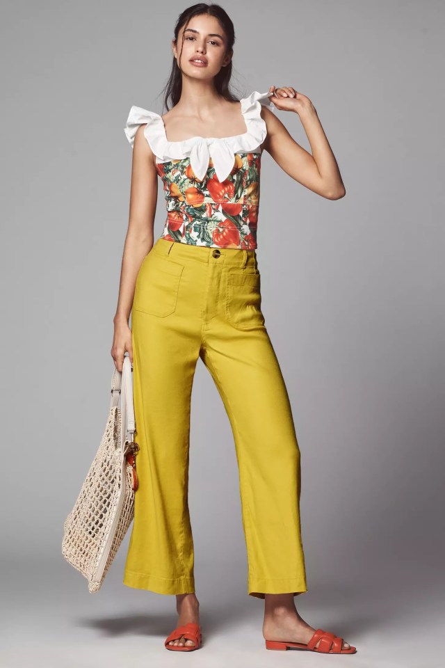 person wearing yellow linen pants and a floral top