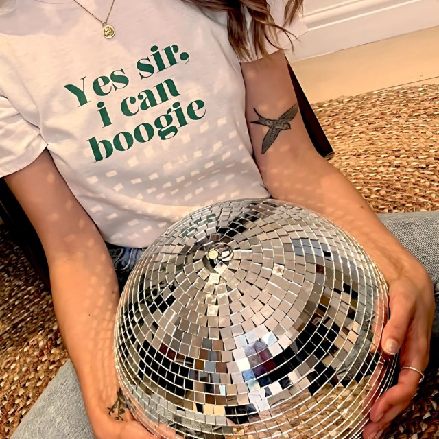 person holding a disco ball while wearing the t-shirt