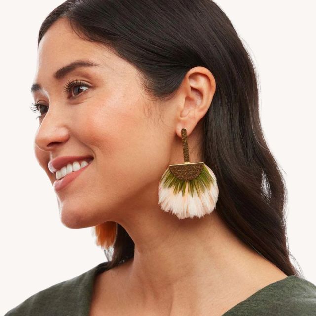 woman wearing pink and green feather statement earrings