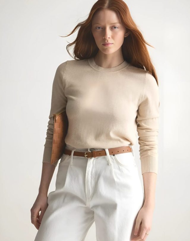 Person wearing the sweater, white pants, and carrying a clutch