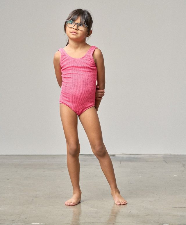 child wearing a pink one-piece swimsuit