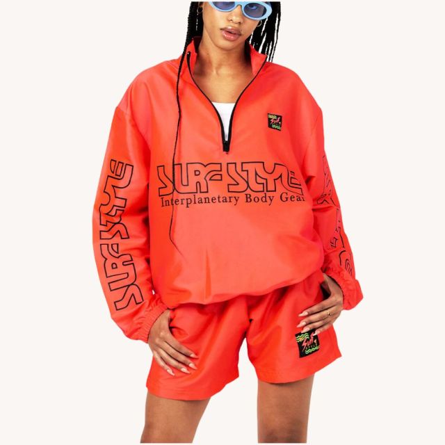 woman wearing coral windbreaker and shorts