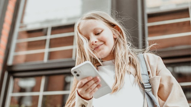 a tween girl looking at her phone for a story on online safety for kids