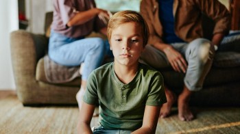 boy listening to parents talk behind him