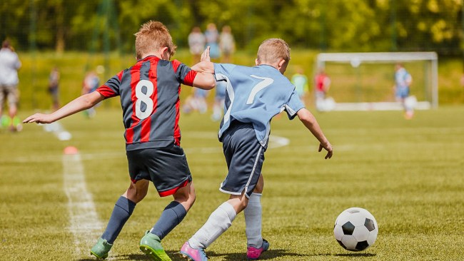 kids playing soccer and taking performance coach's advice
