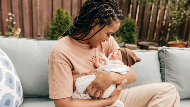 A woman gazing adoringly at her newborn after receiving the best gift for new moms