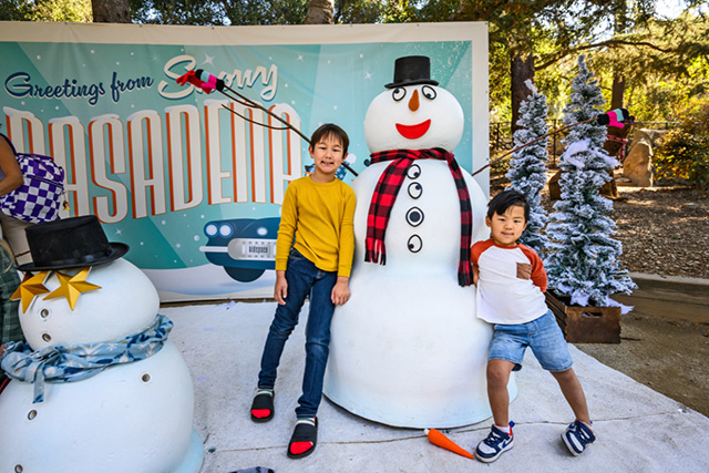 Two kids posing with their "snowman" at Kidspace's Winter Frolic in LA