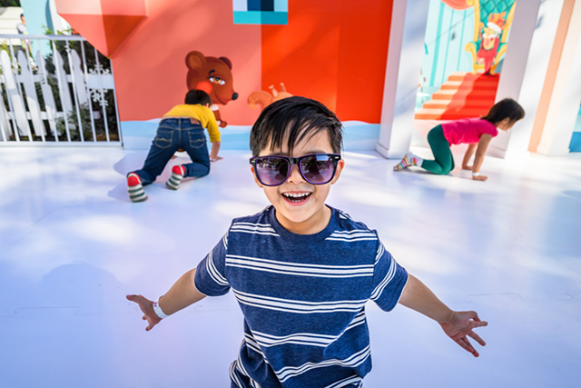 a little boy in sunglasses sock skating at kidspace's winter frolic in LA