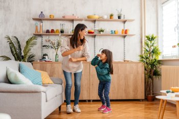 mom and girl dancing together at home