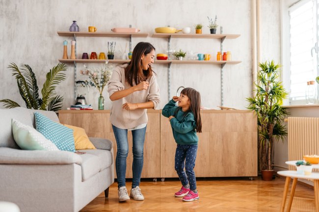 mom and girl dancing together at home