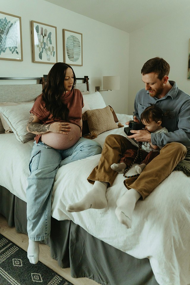 A family in bed reading to their toddler, one of the best faceless photo ideas