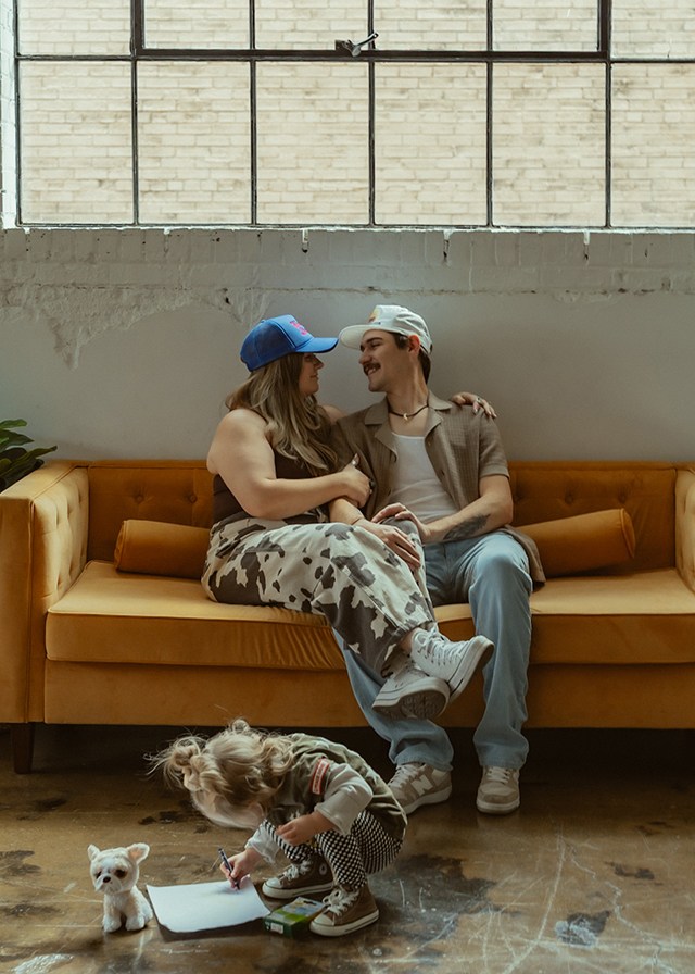 parents cuddling while kid plays, one of the best faceless photo ideas