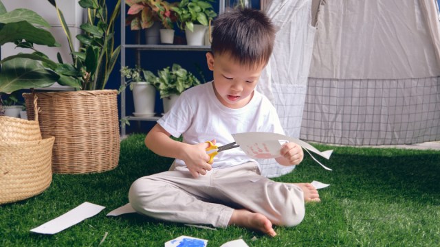 A little boy doing an outdoor art project that's easy to clean up