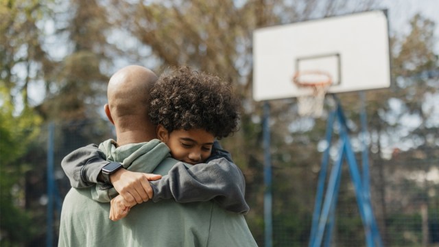 a dad and his son playing basketball and hugging for a story on things we should all be telling our sons