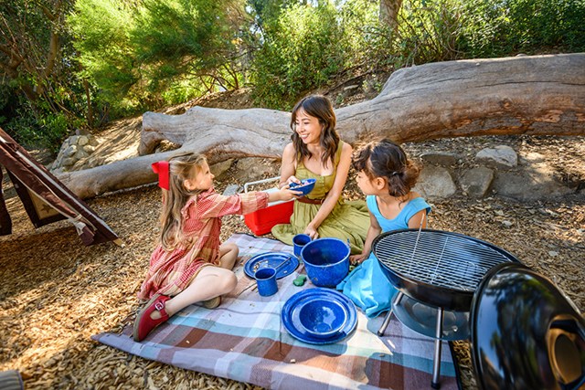 A mom and her kids bonding outside at Kidspace Campout